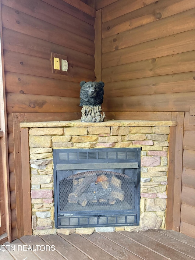 details with rustic walls, a fireplace, and wood finished floors