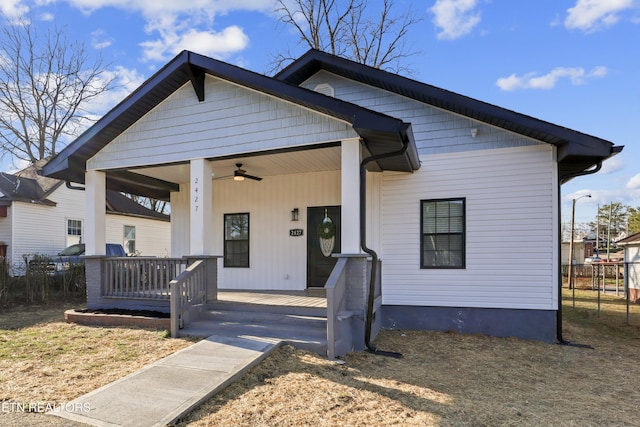 bungalow-style home featuring a porch, fence, and a ceiling fan