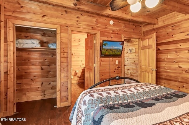 bedroom featuring dark wood finished floors, wooden ceiling, wood walls, and beamed ceiling