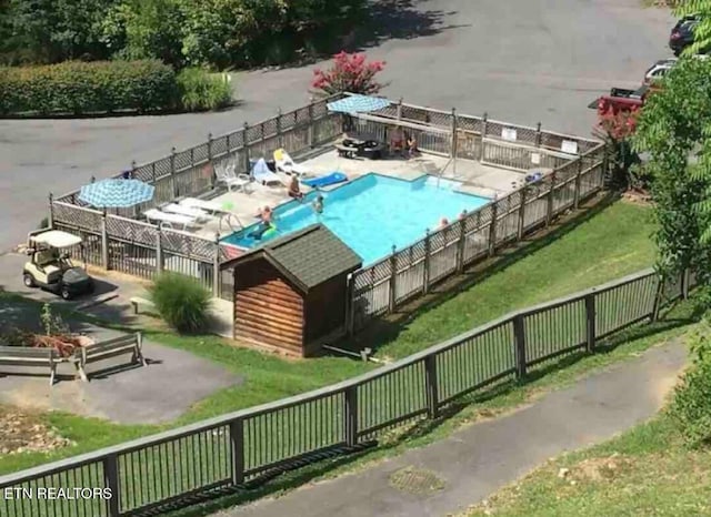 pool with a yard and fence