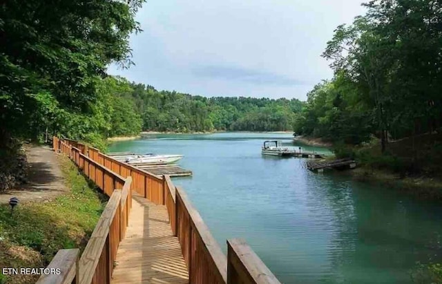 property view of water with a floating dock and a view of trees