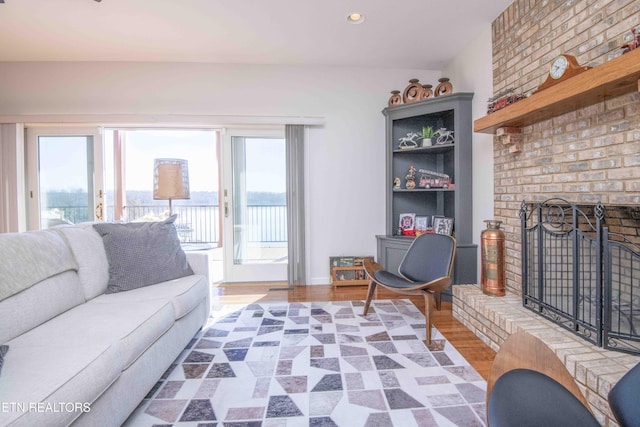 living area featuring light wood-style floors, recessed lighting, and a fireplace