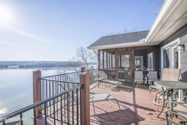 wooden terrace featuring a water view and a sunroom