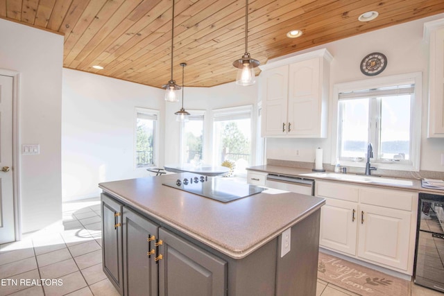 kitchen featuring black electric stovetop, stainless steel dishwasher, white cabinetry, a sink, and a kitchen island