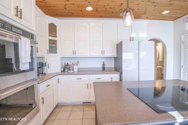 kitchen with white cabinets, wood ceiling, black electric cooktop, and freestanding refrigerator