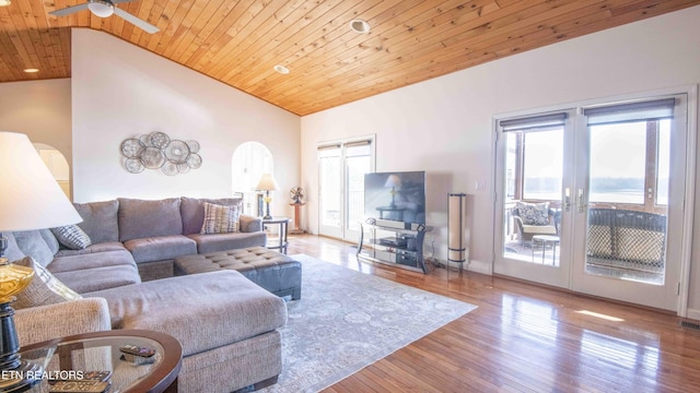 living room featuring arched walkways, ceiling fan, wood finished floors, wood ceiling, and french doors