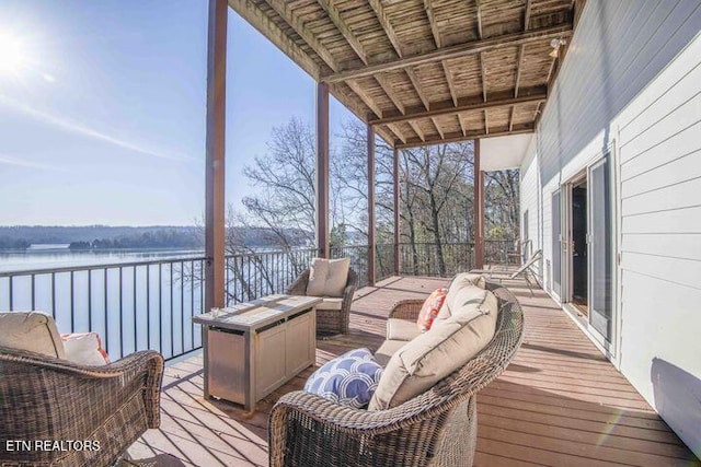 wooden deck with outdoor lounge area and a water view