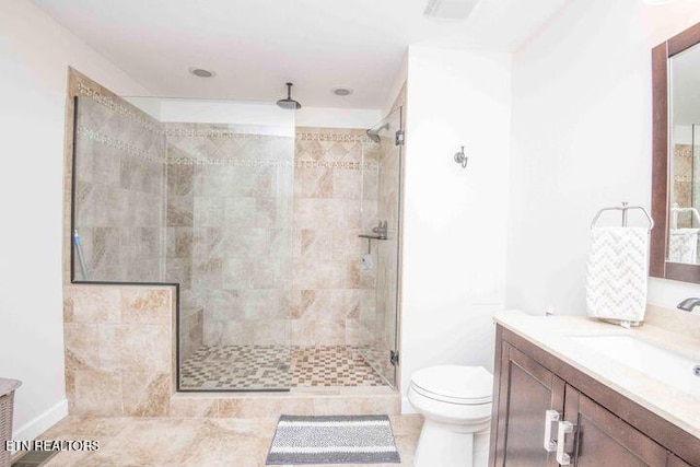 bathroom with toilet, a shower stall, and vanity