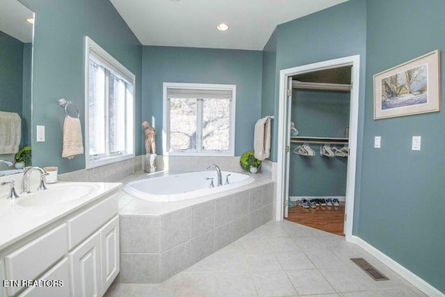 full bathroom with visible vents, tile patterned flooring, a spacious closet, vanity, and a bath