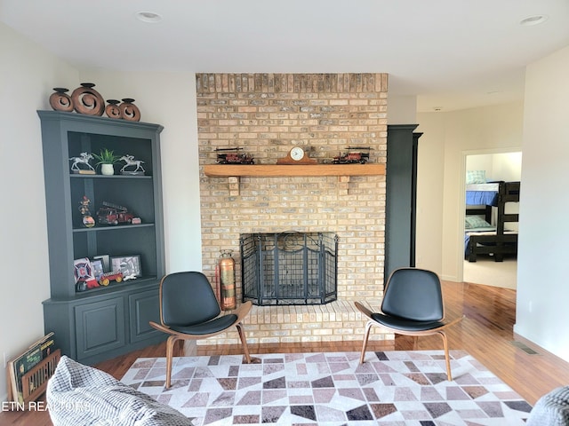 living area with a fireplace, wood finished floors, and baseboards