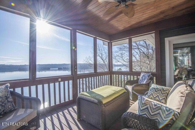 sunroom with a water view, plenty of natural light, wood ceiling, and ceiling fan