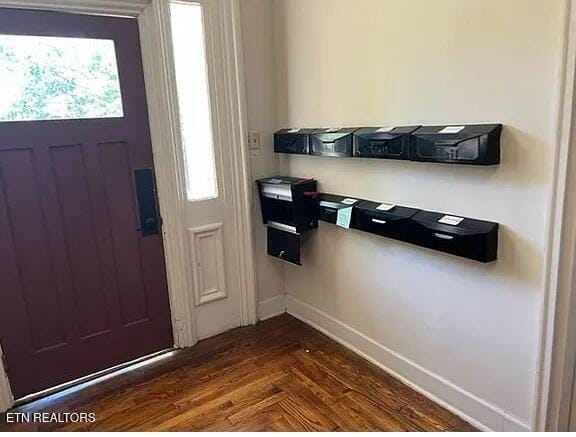 foyer entrance featuring baseboards and dark wood-style floors