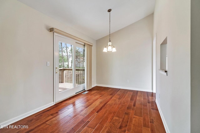 unfurnished dining area with an inviting chandelier, baseboards, vaulted ceiling, and hardwood / wood-style floors