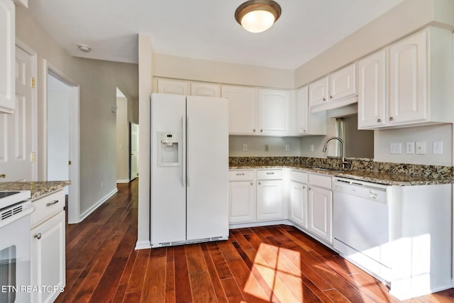 kitchen featuring dark wood-style flooring, white appliances, stone counters, and a sink