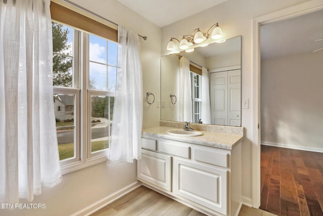 bathroom featuring wood finished floors, vanity, and baseboards