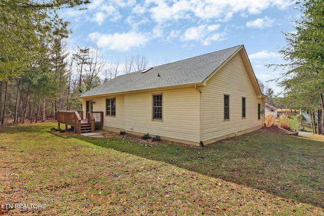 back of house featuring a yard, a shingled roof, and a wooden deck