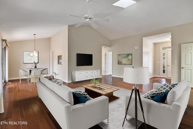 living room with dark wood-type flooring, vaulted ceiling, baseboards, and ceiling fan with notable chandelier