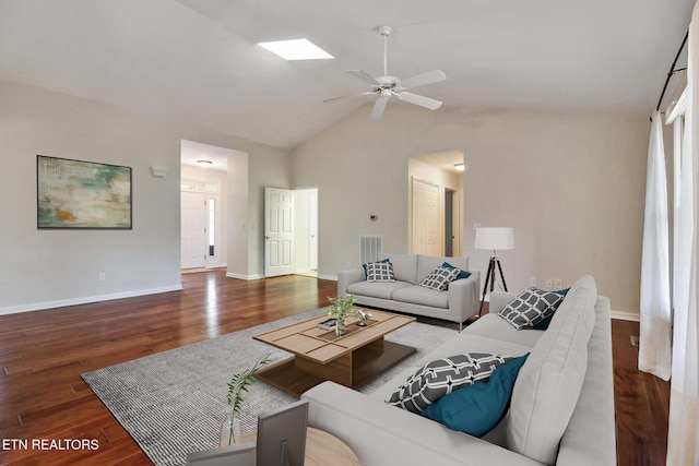 living area with vaulted ceiling with skylight, visible vents, baseboards, and wood finished floors