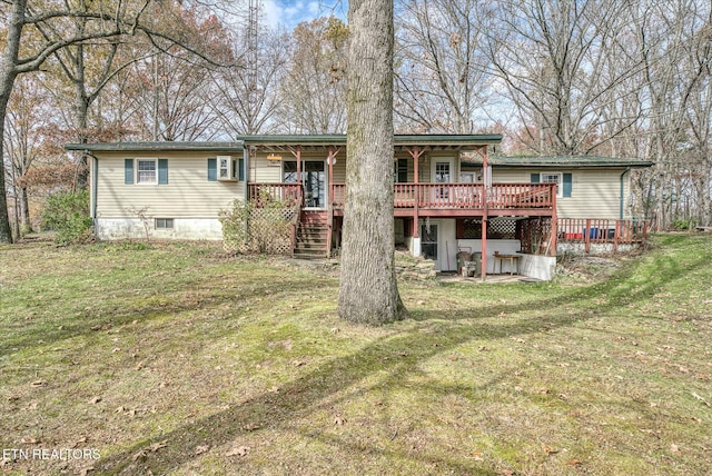 rear view of house with stairway, a deck, and a lawn