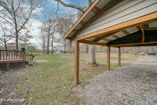 view of yard with a carport and a wooden deck