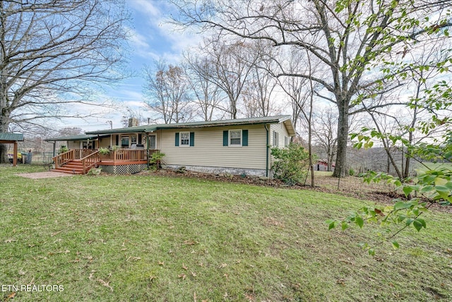 back of house featuring a lawn and a wooden deck