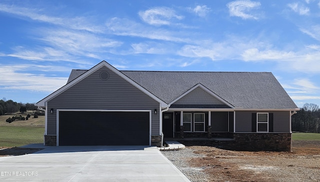 view of front facade with a garage, stone siding, and concrete driveway