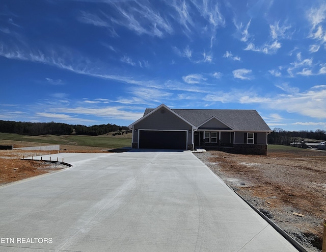 ranch-style home featuring concrete driveway and an attached garage