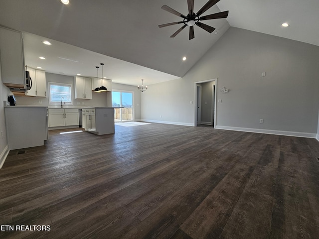 unfurnished living room with dark wood finished floors, a sink, ceiling fan, high vaulted ceiling, and baseboards