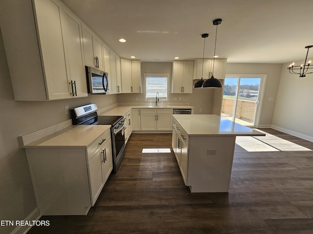 kitchen featuring plenty of natural light, a kitchen island, appliances with stainless steel finishes, and dark wood-style flooring