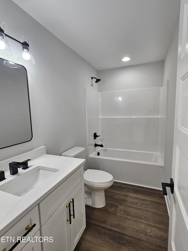 full bathroom with toilet, shower / bath combination, wood finished floors, and vanity