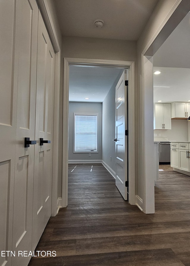 hall with dark wood finished floors and baseboards