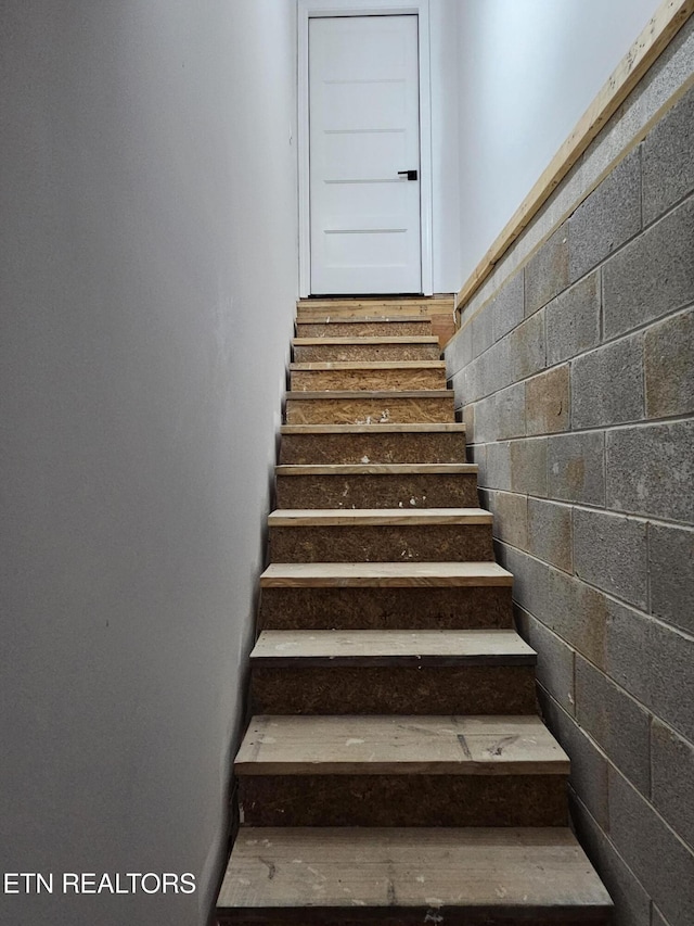 staircase with concrete block wall