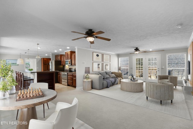 living room with light carpet, ceiling fan, a textured ceiling, and recessed lighting