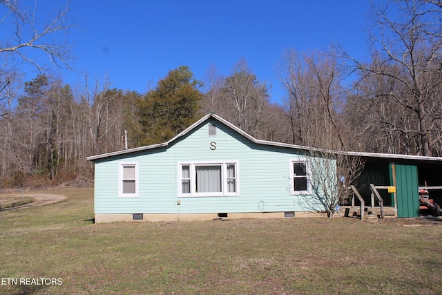 rear view of property with crawl space and a yard