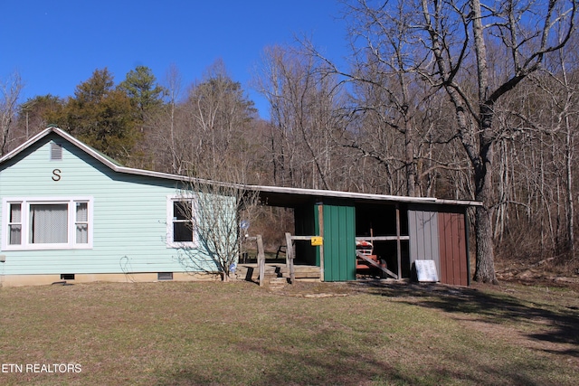 back of house featuring a pole building, an outbuilding, crawl space, and a yard