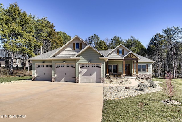 craftsman-style house featuring a garage, stone siding, covered porch, and concrete driveway