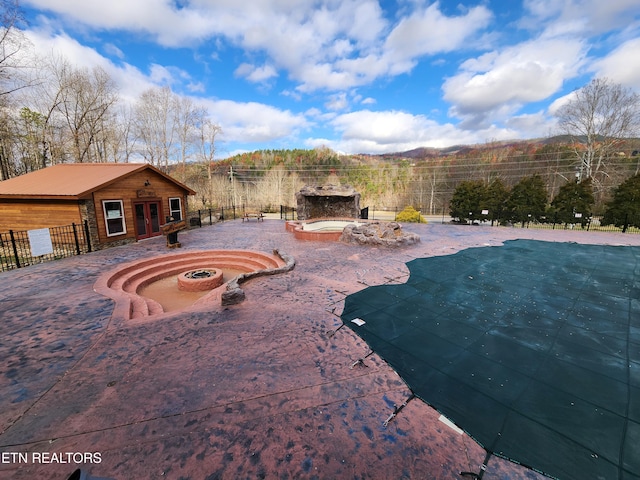 view of swimming pool featuring a fire pit, a patio, an outdoor fireplace, and fence