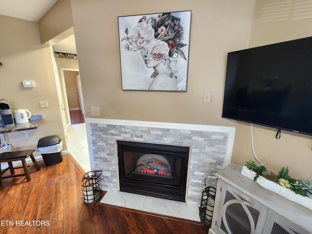 living room with a fireplace and wood finished floors