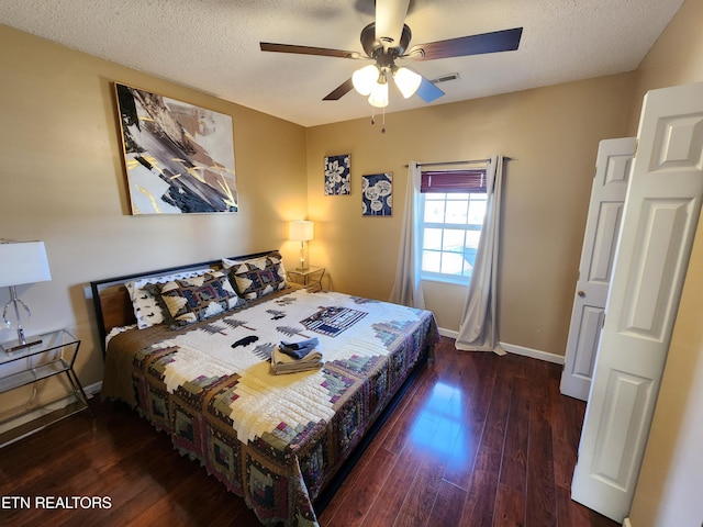 bedroom featuring visible vents, baseboards, a ceiling fan, wood finished floors, and a textured ceiling