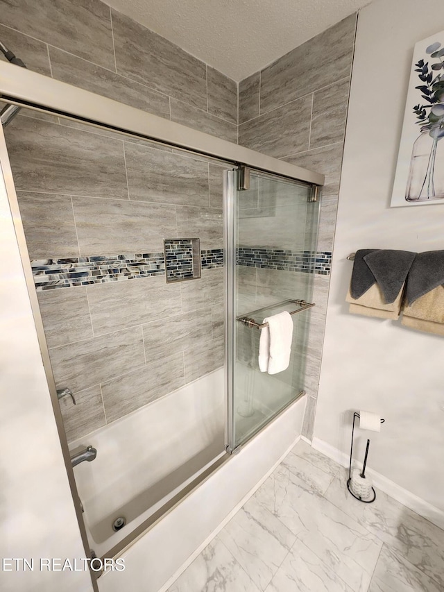 bathroom with marble finish floor, baseboards, and bath / shower combo with glass door