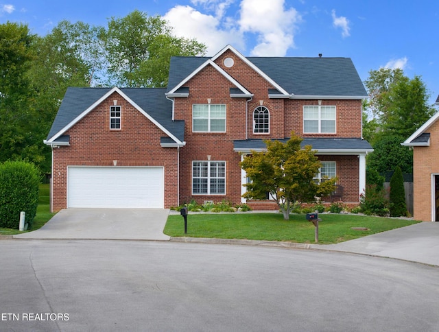 view of front of property with driveway, a garage, a front lawn, and brick siding