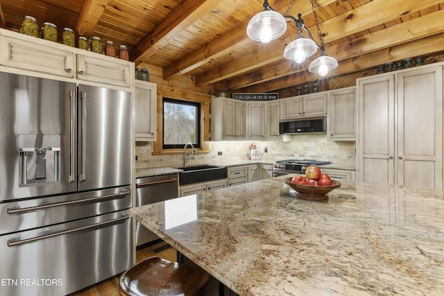 kitchen featuring a sink, light stone countertops, tasteful backsplash, and premium appliances