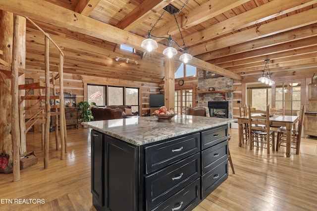 kitchen featuring wooden ceiling, light wood-style flooring, open floor plan, and dark cabinets