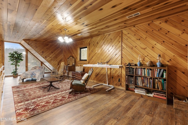 sitting room featuring wood walls, wood ceiling, visible vents, and wood finished floors