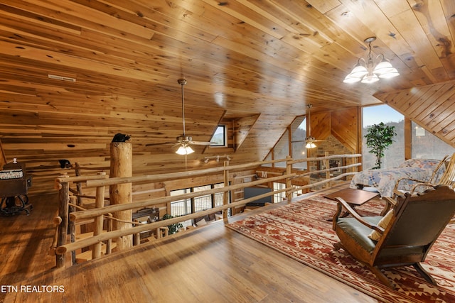 interior space with lofted ceiling, wood walls, wooden ceiling, and wood finished floors