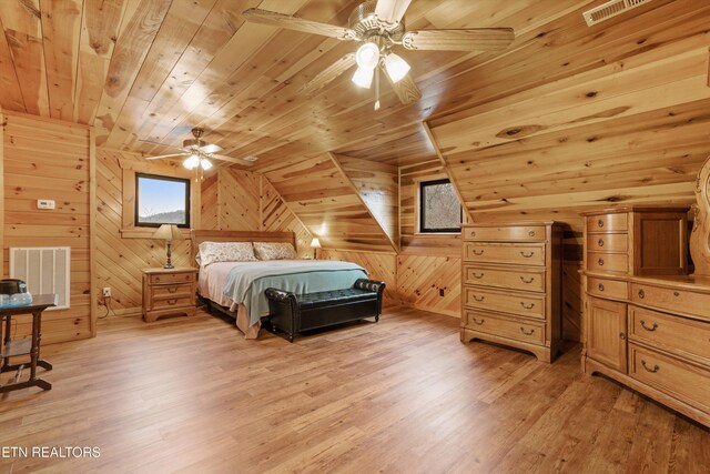 bedroom with wooden ceiling, light wood-style floors, wooden walls, and visible vents