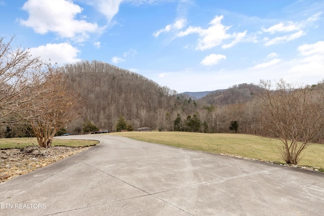 view of street featuring a mountain view and a wooded view