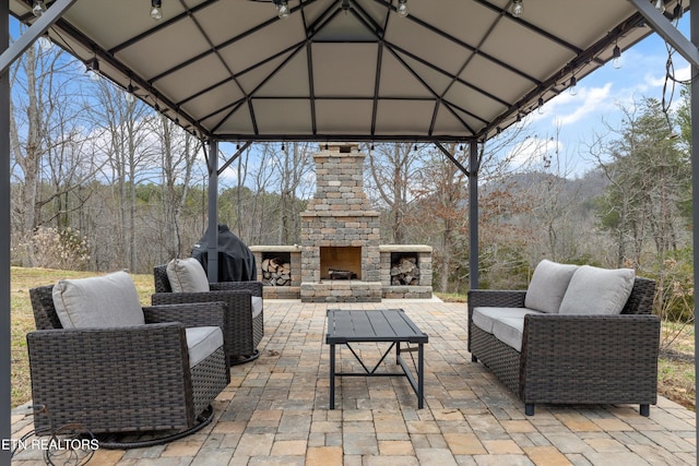 view of patio / terrace with a gazebo and an outdoor living space with a fireplace