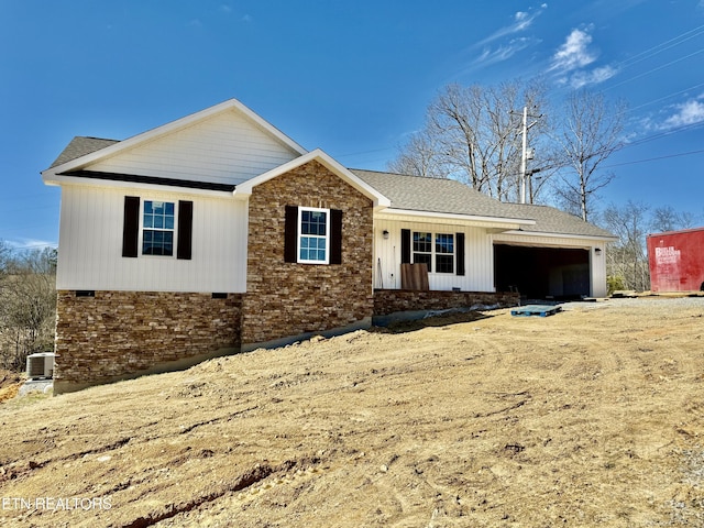 single story home featuring cooling unit, brick siding, an attached garage, and roof with shingles