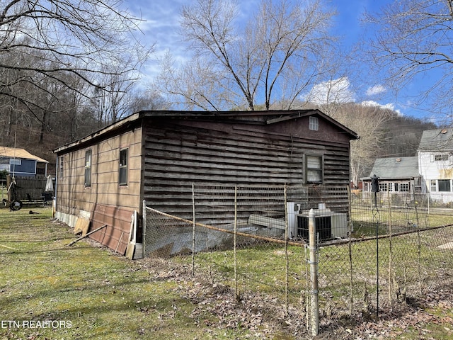 view of outdoor structure featuring central AC and fence